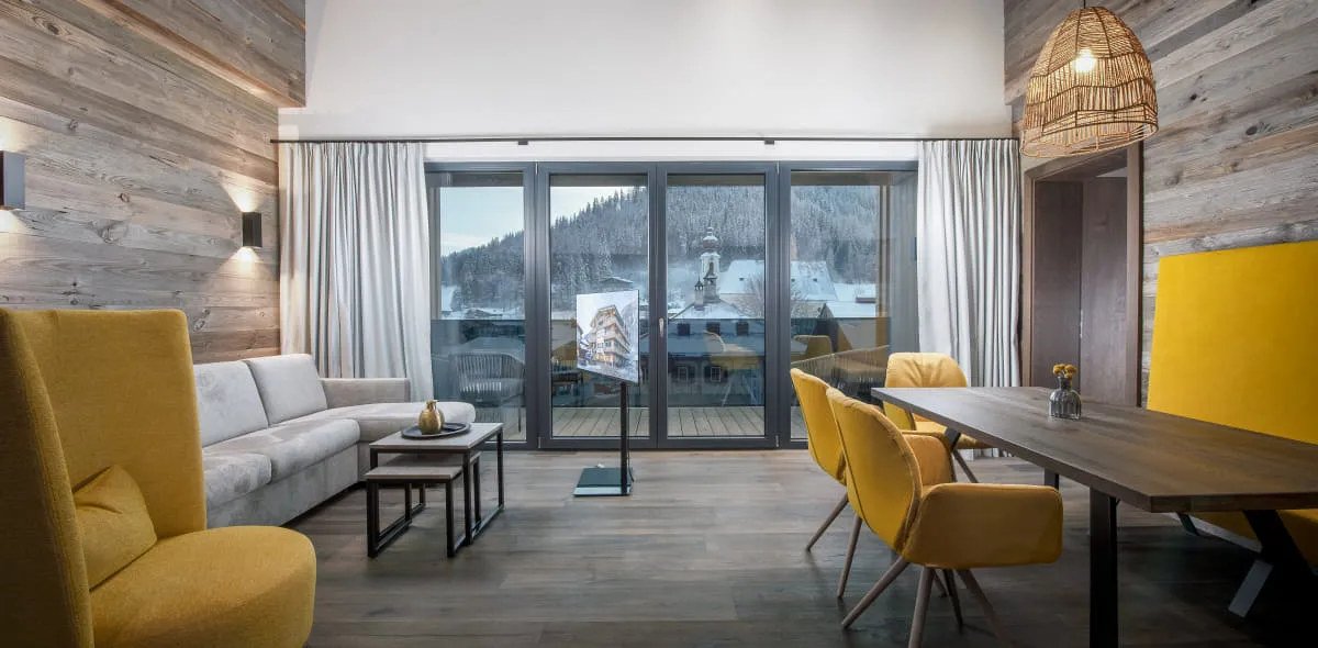 Moderner, großzügiger Wohnbereich im Appartement mit verschiedenen gelben Designelementen