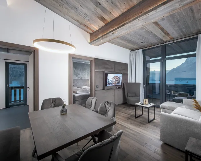 Wohnzimmer mit Essbereich und angrenzender Couch in Grautönen