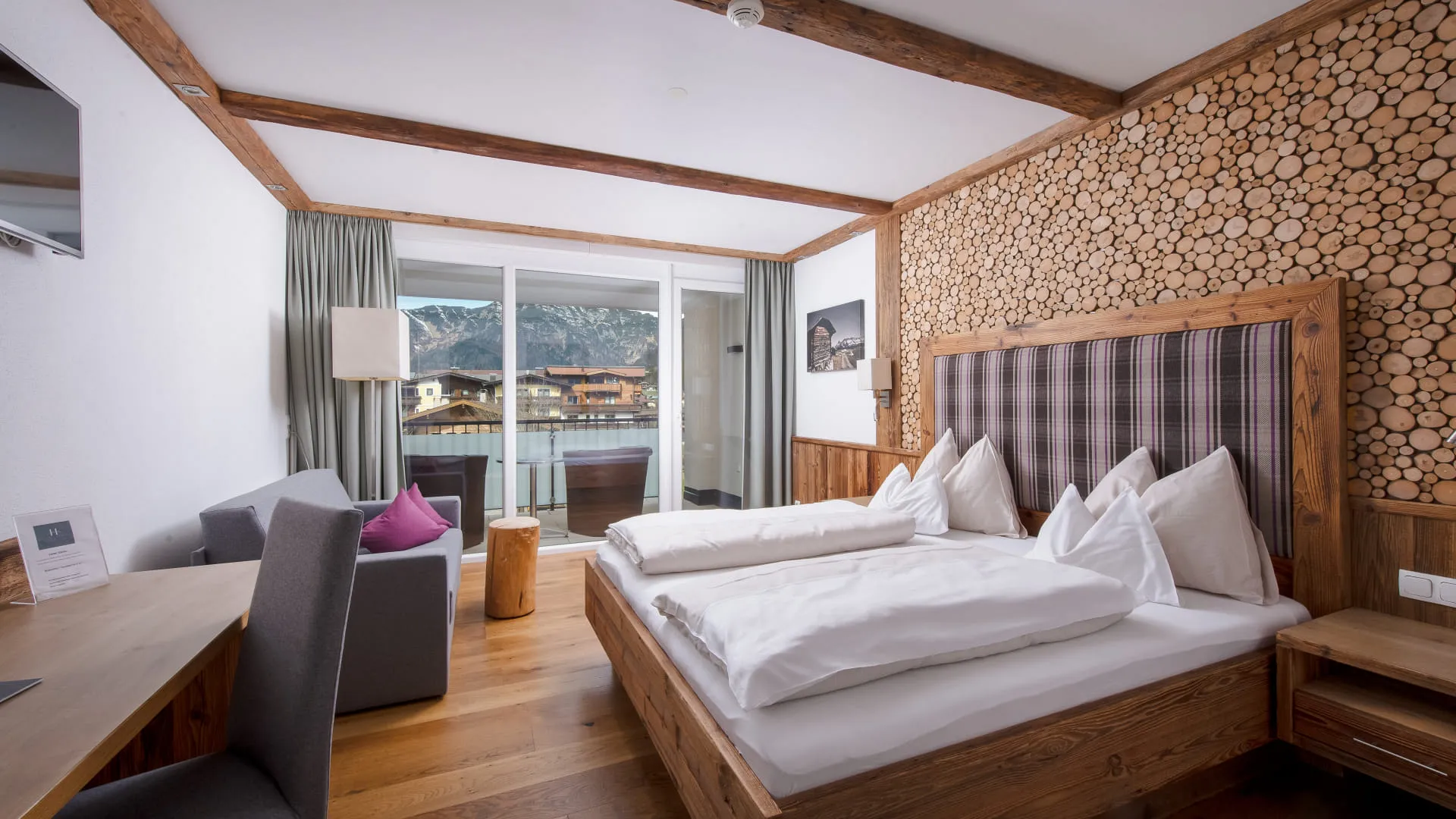 Helles Schlafzimmer mit großem Doppelbett, Schreibtisch und kleiner Couch
