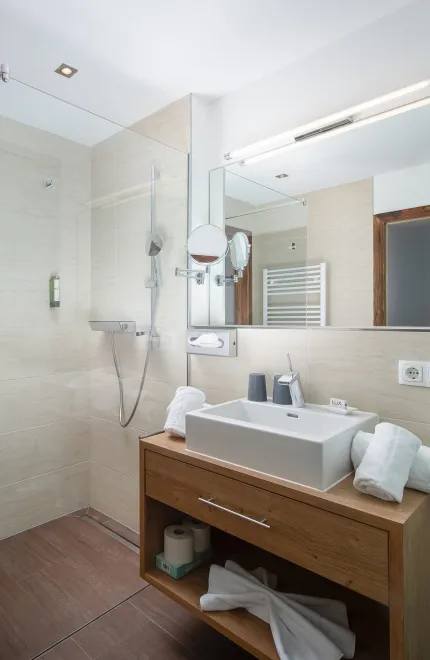 Modernes Badezimmer mit großen Glaselementen und hellen Farben