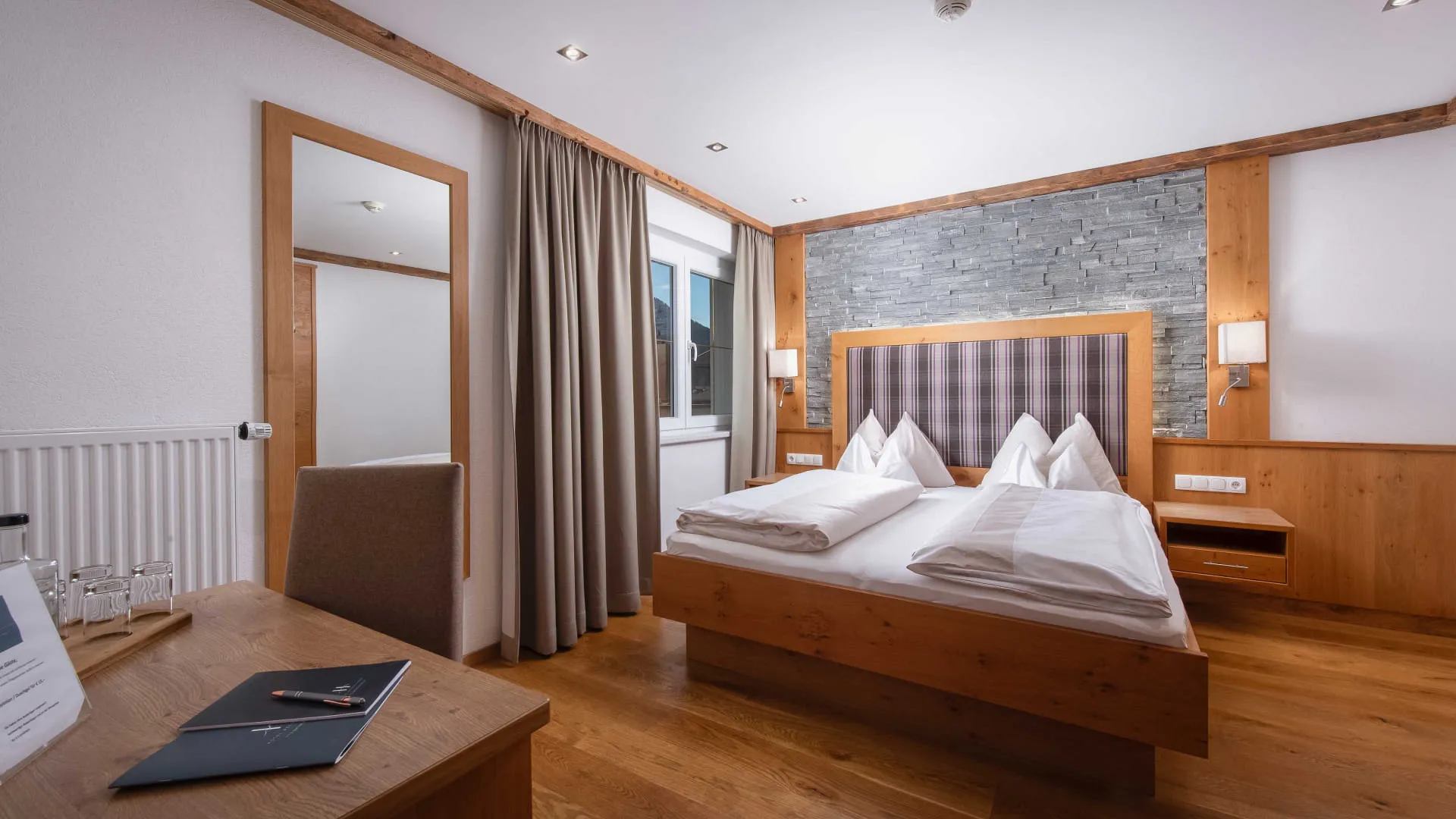 Helles, modernes Schlafzimmer mit großem Doppelbett und Schreibtisch