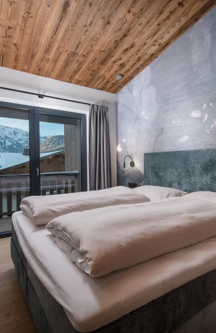 Großzügiges Doppelbett vor Designtapete mit Wasserstruktur